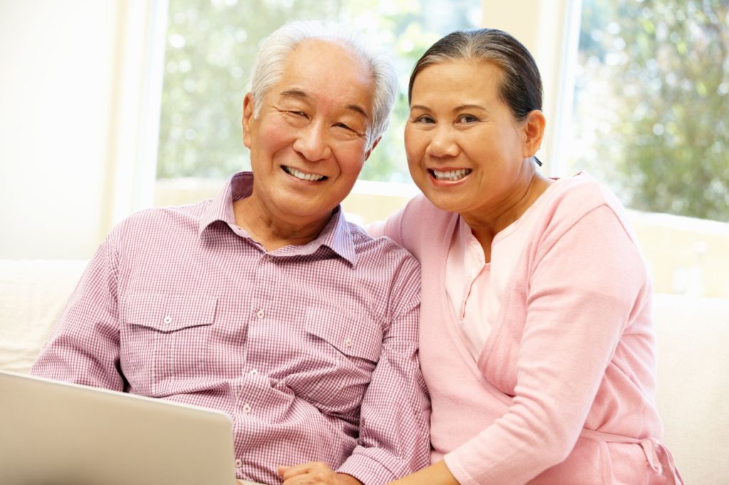 Elderly Asian couple sitting on couch